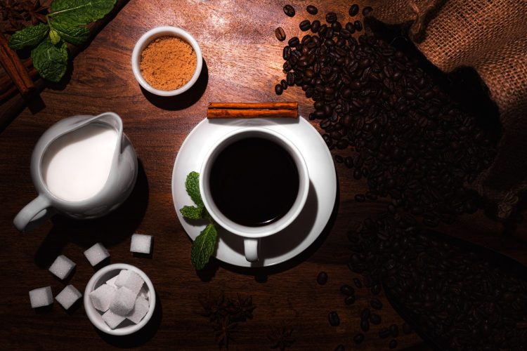 A top view of a dark coffee served with sugar cubes